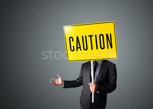 Om de afaceri prudenta semna în picioare galben Imagine de stoc © ra2studio