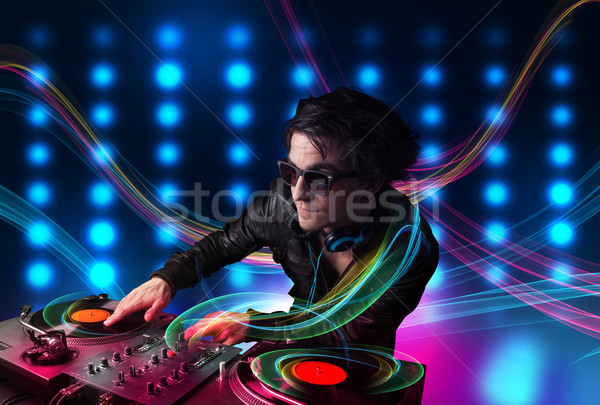 Young Dj mixing records with colorful lights Stock photo © ra2studio