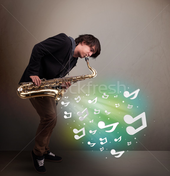Jóvenes músico jugando saxófono notas musicales atractivo Foto stock © ra2studio