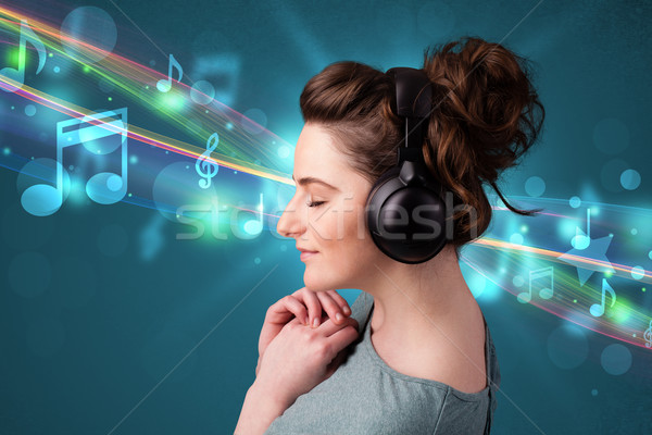 Young woman listening to music with headphones Stock photo © ra2studio