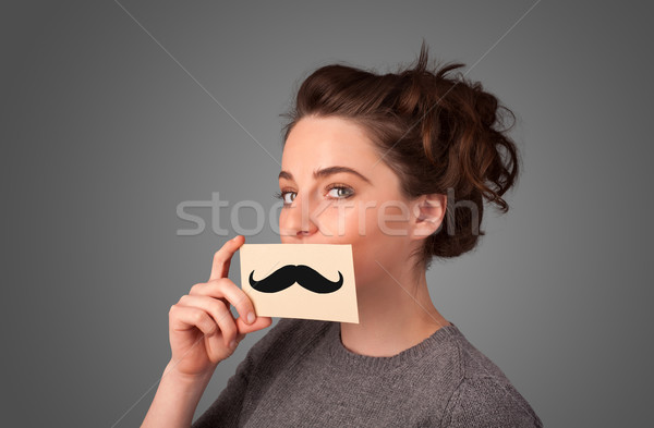 Happy cute girl holding paper with mustache drawing  Stock photo © ra2studio