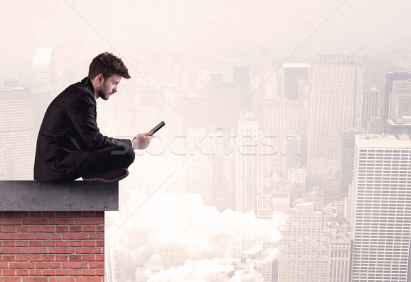 Office worker sitting on rooftop in city Stock photo © ra2studio