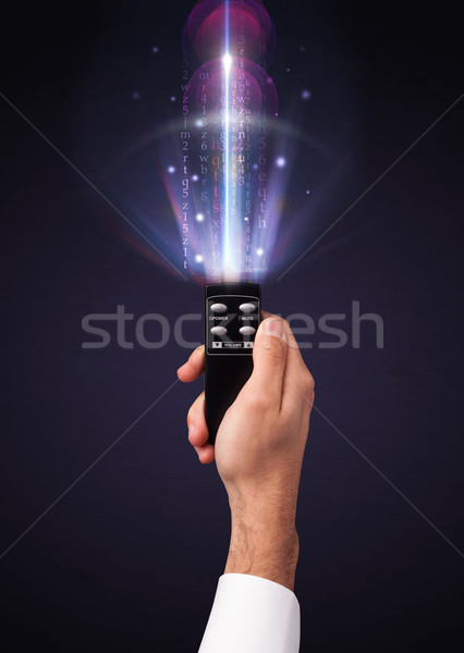 Hand with remote control and shining numbers Stock photo © ra2studio