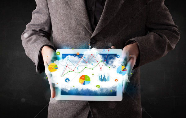 Person holding a touchpad with cloud technology and charts Stock photo © ra2studio