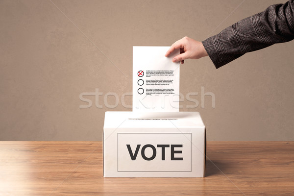 Close up of male hand putting vote into a ballot box Stock photo © ra2studio