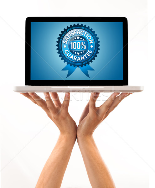 Stock photo: male hand holding a laptop with Satisfaction Guarantee Labe
