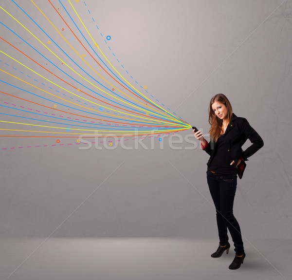 Stock photo: Happy girl holding a phone with colorful abstract lines