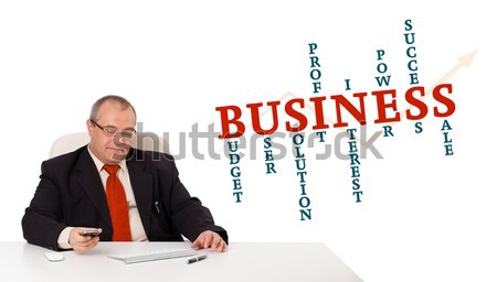 businessman sitting at desk and holding a mobilephone with business word cloud, isolated on white Stock photo © ra2studio
