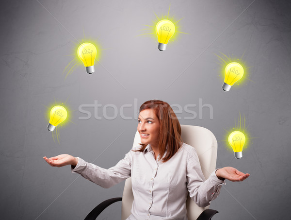 young lady sitting and juggling with light bulbs Stock photo © ra2studio