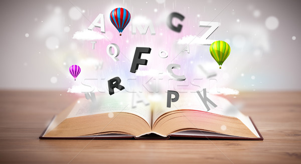 Open book with flying 3d letters on concrete background Stock photo © ra2studio