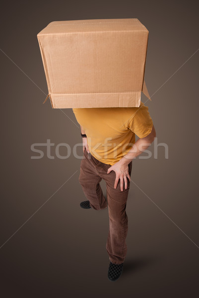 Young man gesturing with a cardboard box on his head Stock photo © ra2studio