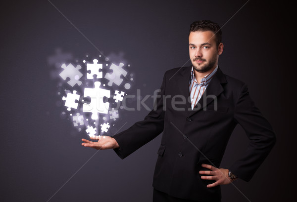 Puzzle pieces in the hand of a businessman Stock photo © ra2studio