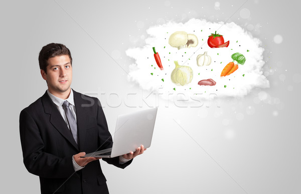 Handsome man presenting a cloud of healthy nutritional vegetable Stock photo © ra2studio