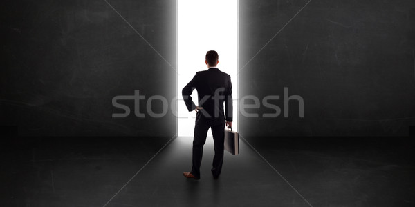 Uomo d'affari guardando muro luce tunnel apertura Foto d'archivio © ra2studio