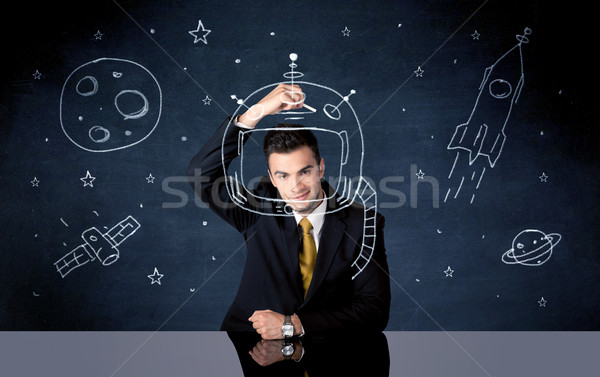 Sales person drawing helmet and space rocket Stock photo © ra2studio