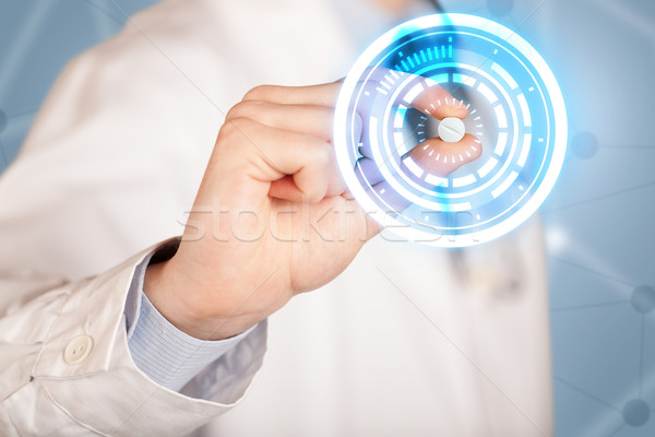 Male doctor holding a pill with glowing circles Stock photo © ra2studio