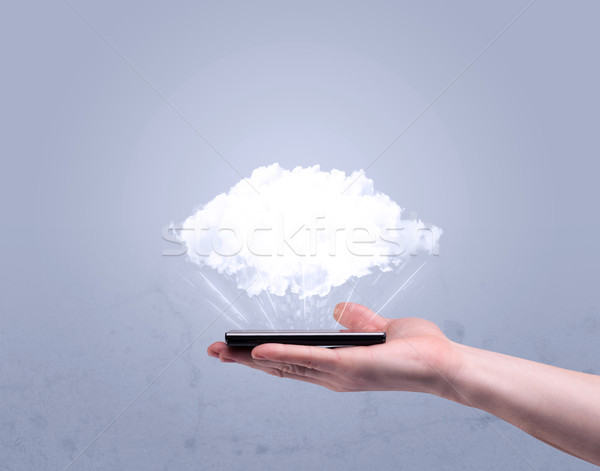 Hand holding phone with empty cloud Stock photo © ra2studio