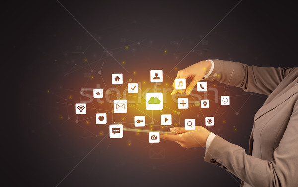 Hand holding tablet and application icons above Stock photo © ra2studio