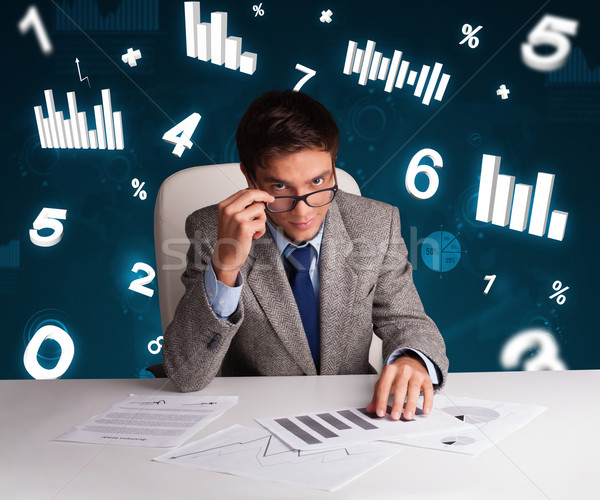 Businessman sitting at desk with diagrams and statistics Stock photo © ra2studio