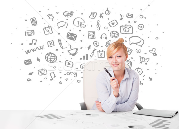 Beautiful young businesswoman with all kind of hand-drawn media icons in background Stock photo © ra2studio