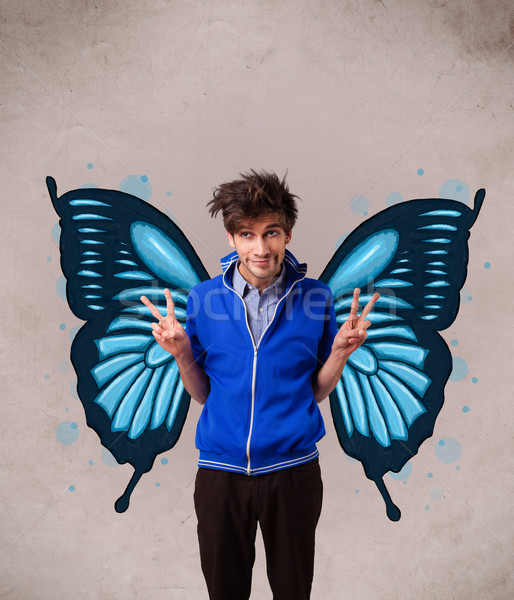 Handsome young man with butterfly blue illustration on the back Stock photo © ra2studio