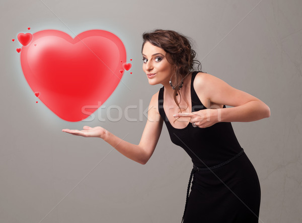 Young lady holding lovely 3d red heart Stock photo © ra2studio
