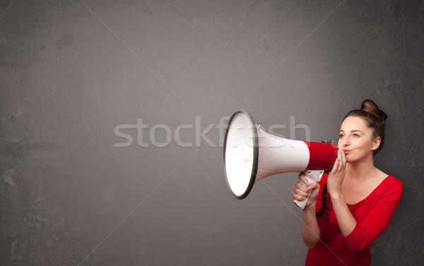 Girl shouting into megaphone on copy space background Stock photo © ra2studio