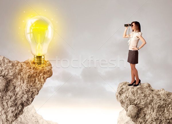 Businesswoman on rock mountain with idea bulb Stock photo © ra2studio