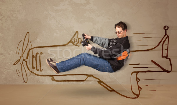 Funny pilot driving a hand drawn airplane on the wall Stock photo © ra2studio