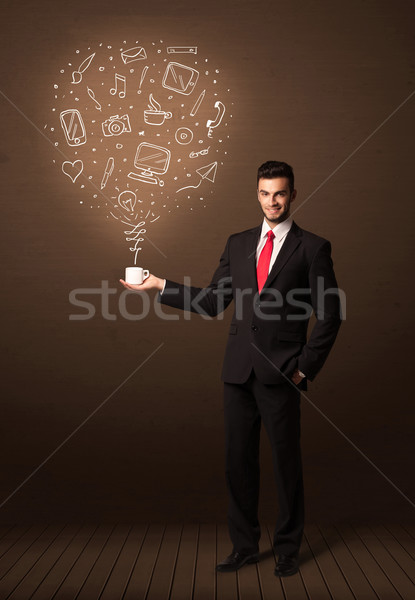 Businessman holding a white cup with social media icons Stock photo © ra2studio