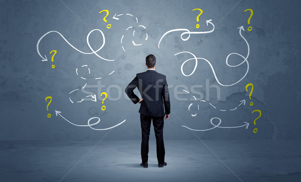 Unsure businessman with question marks Stock photo © ra2studio