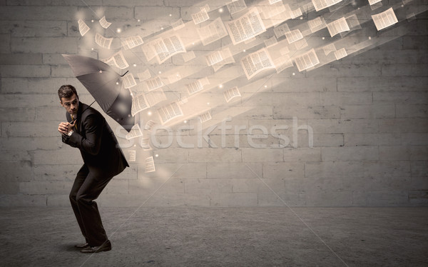 Business man protecting with umbrella against wind of papers Stock photo © ra2studio