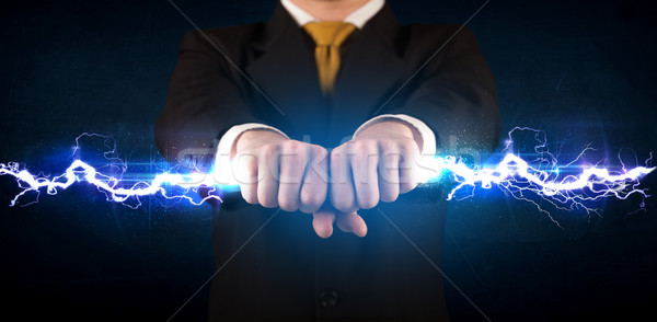 Stock photo: Business man holding electricity light bolt in his hands