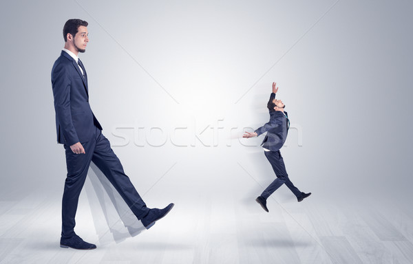 Giant businessman kicking out little businessman  Stock photo © ra2studio