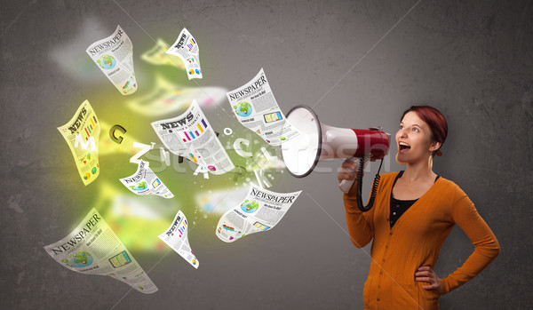 Girl yelling into loudspeaker and newspapers fly out Stock photo © ra2studio