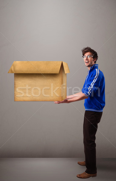 Goog-looking man holding an empty brown cardboard box Stock photo © ra2studio