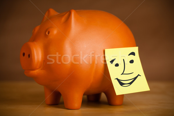 Post-it note with smiley face sticked on piggy bank Stock photo © ra2studio