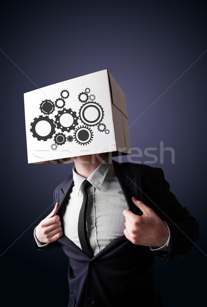 Businessman gesturing with a cardboard box on his head with spur Stock photo © ra2studio