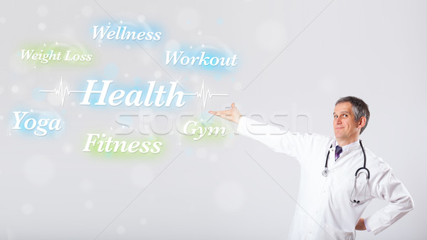 Clinical doctor pointing to health and fitness collection of wor Stock photo © ra2studio