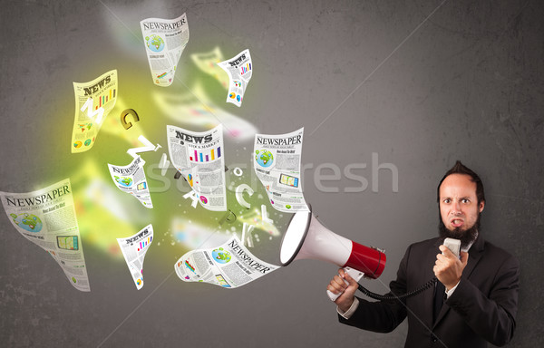 Guy yelling into loudspeaker and newspapers fly out Stock photo © ra2studio