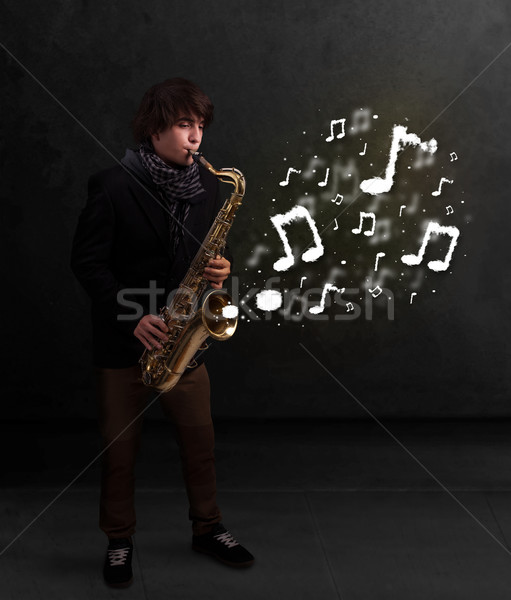 Handsome musician playing on saxophone with musical notes Stock photo © ra2studio