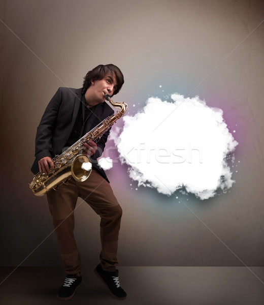 Young man playing on saxophone with copy space in white cloud Stock photo © ra2studio