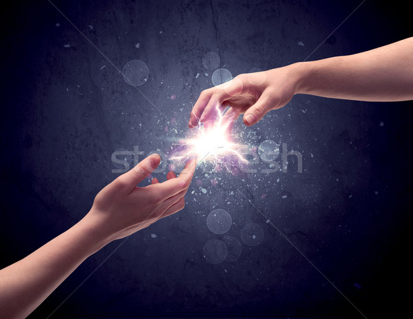 Hands reaching to light a spark Stock photo © ra2studio