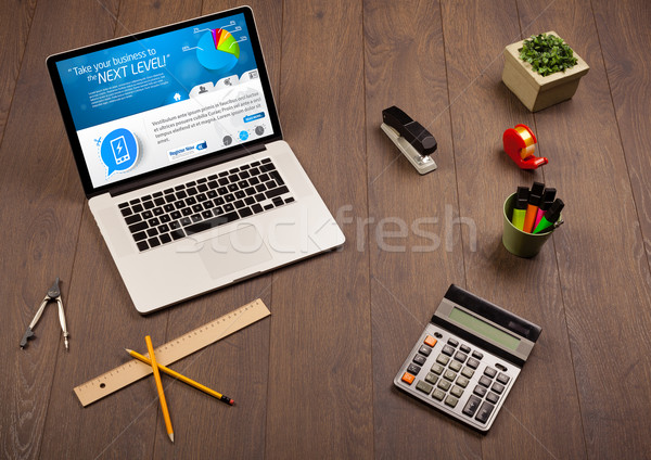 Laptop on office desk with business website on screen Stock photo © ra2studio