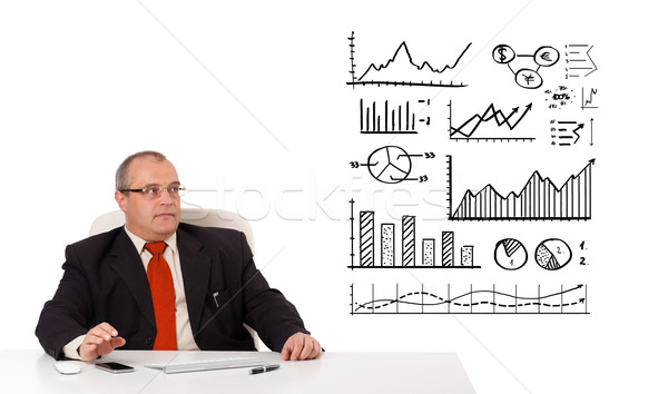 Businessman sitting at desk with diagrams and graphs Stock photo © ra2studio