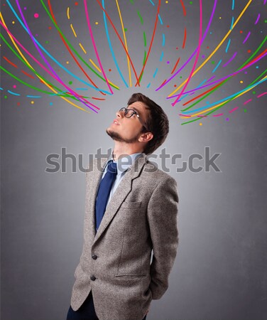 Young man thinking wiht colorful abstract lines overhead Stock photo © ra2studio