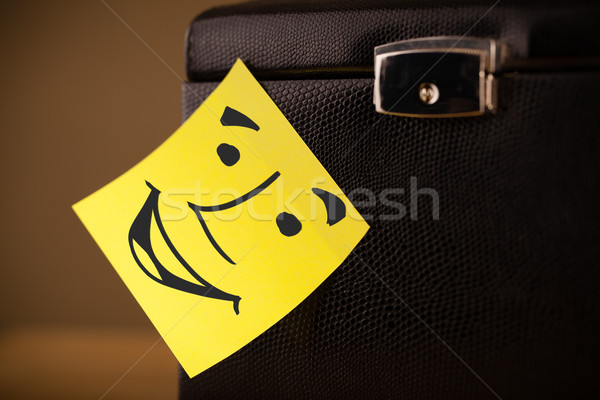 Stock photo: Post-it note with smiley face sticked on a box