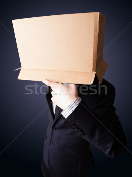 Businessman gesturing with a cardboard box on his head Stock photo © ra2studio