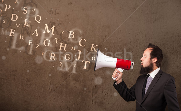 Man in shirt shouting into megaphone and text come out Stock photo © ra2studio