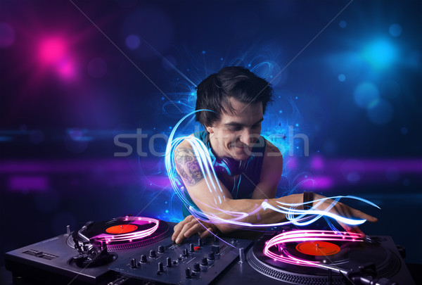 Disc jockey playing music with electro light effects and lights Stock photo © ra2studio